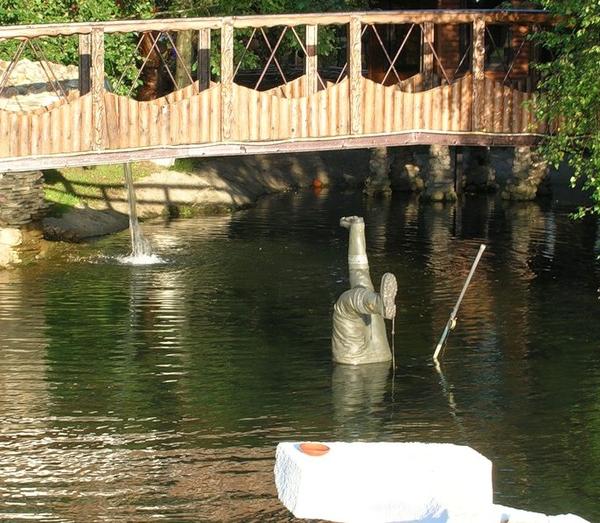 Памятник рыбаку в реке.